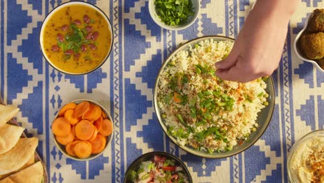 sprinkling pepper on couscous with chicken on table close-up. arabian cuisine. pita and bean soup. traditional middle eastern culture. delicious rice with meat. homemade food concept