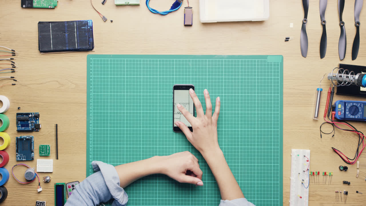 vista superior mujer ingeniera de software usando pantalla táctil de teléfono inteligente en el escritorio desde arriba - dragón épico rojo