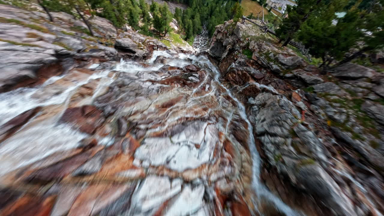 Rushing waterfall near Morteratsch Glacier in rocky alpine landscape