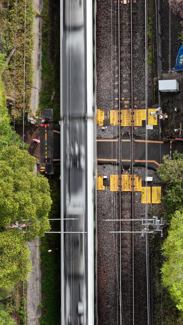 Aerial drone view of a train moving through the Arashiyama train station, Kyoto, Japan in daylight