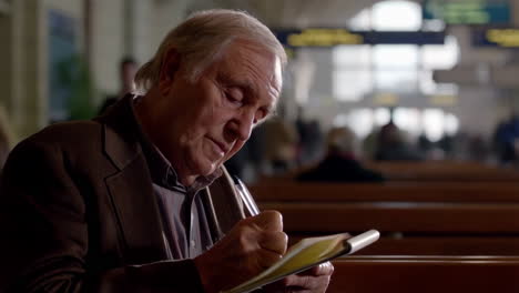 man writing in notebook at airport