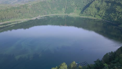 aerial view of a large crater filled with water and became a lake