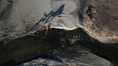 drone vista superior de un estanque y el flujo del río que está muy erosionado con un árbol caído