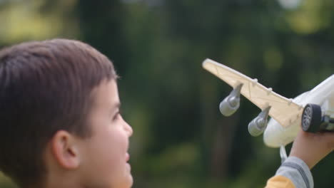 Niño-Pequeño-Jugando-Con-Un-Avión-De-Juguete-Niño-Feliz-Jugando-Imaginando-La-Libertad-De-Viajar-Divirtiéndose-Al-Aire-Libre-En-Un-Parque-Soleado-Disfrutando-De-La-Infancia-4k