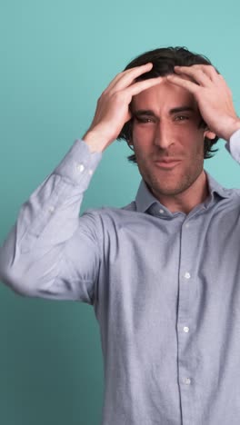 Successful adult man clenching fists in blue studio