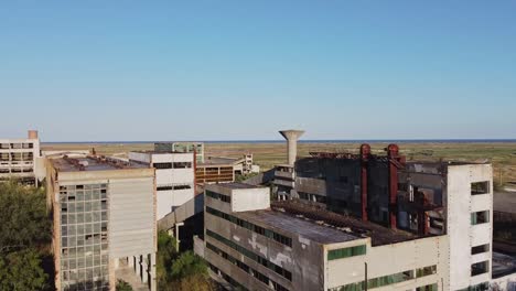 pedestal drone shot revealing an abandoned former rare metals enterprise located near a fishing village aloing the coast of black sea, in the outskirts of vadu, in romania