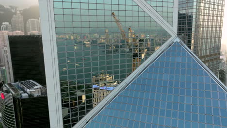 aerial view showing reflection in mirrored window of bank of china building in hong kong city