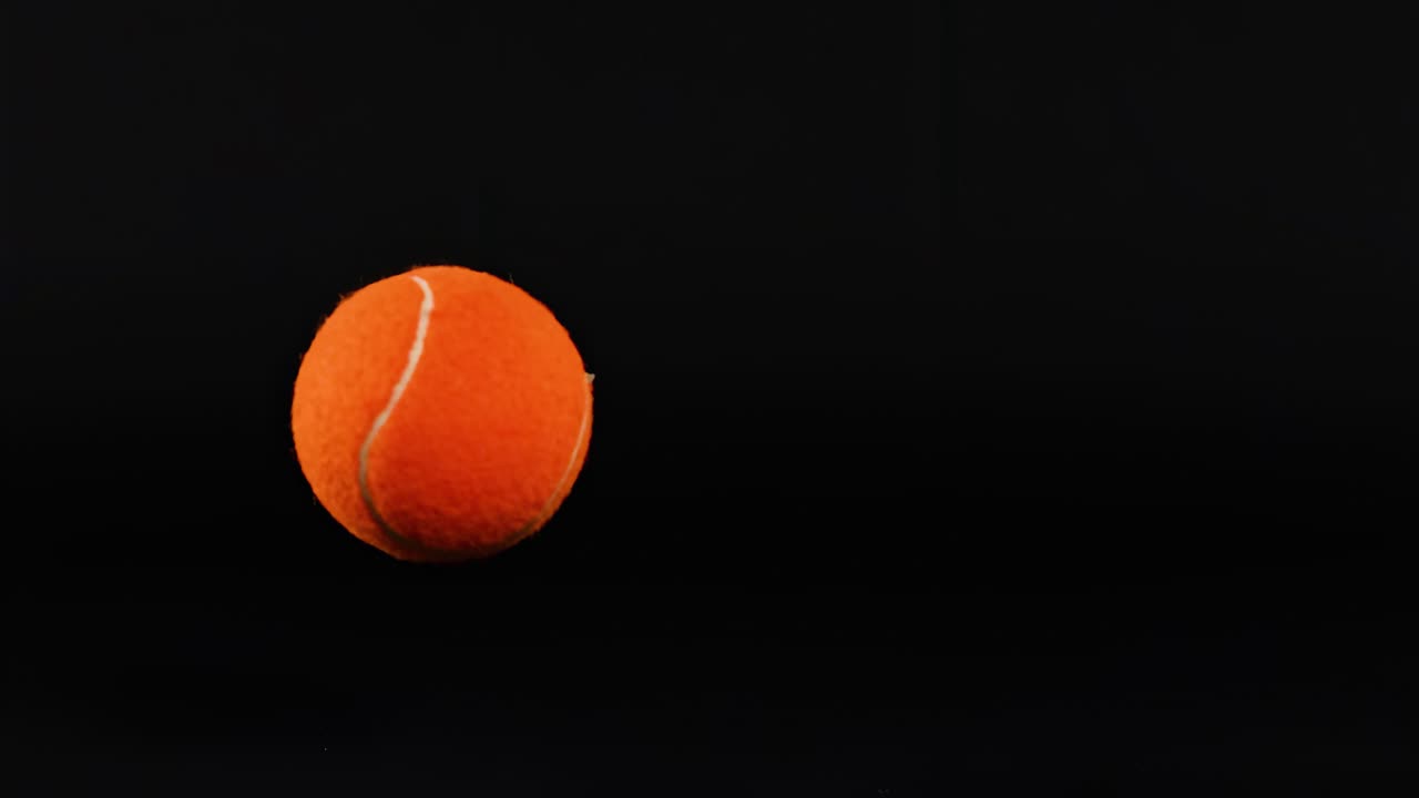 A series of images showing an orange tennis ball in various positions against a dark backdrop.