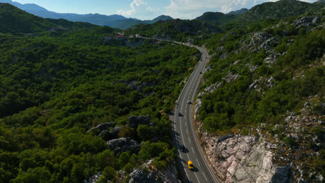 Aerial-view-tracking-traffic-in-the-highlands-of-Budva,-sunny-day-in-Montenegro