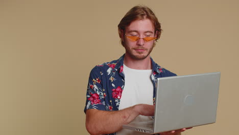 happy man working online on laptop showing thumb up positive feedback, like, lottery win, good offer