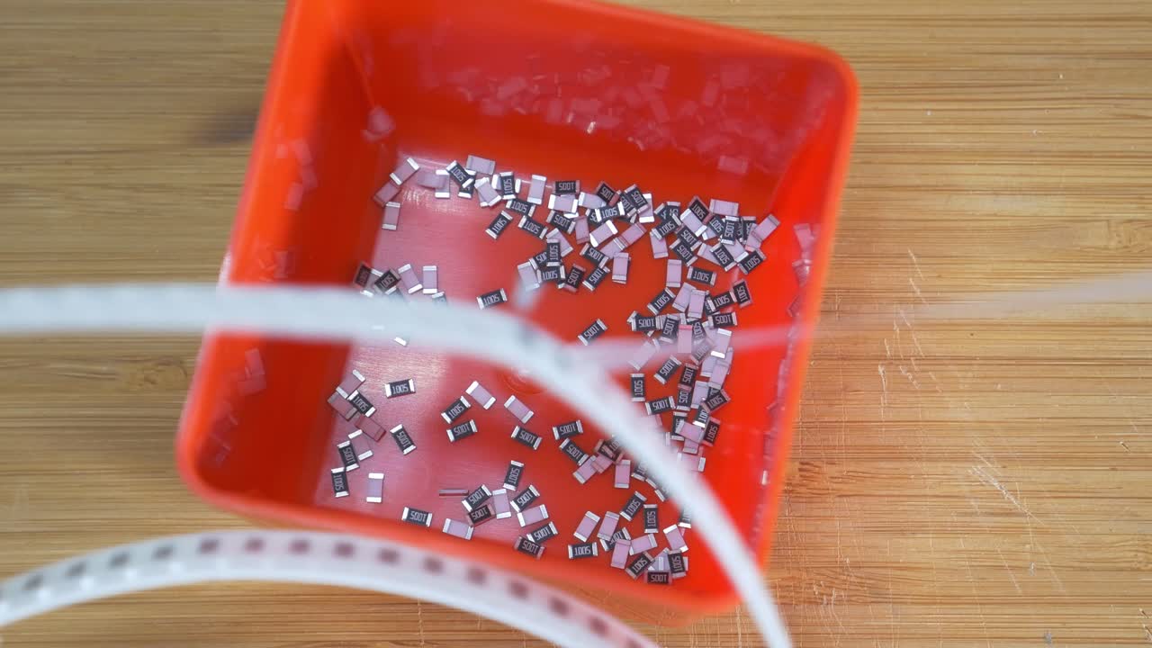 smd 구성 요소 저항기의 릴을 전자 작업장을 구성하는 주황색 상자에 풀기