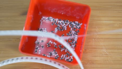 Unpacking-Reel-Of-SMD-Components-Resistors-Into-Orange-Box-Organizing-Electronic-Workshop