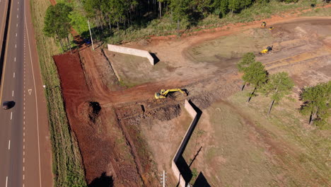 aerial view of machinery working on a roadside excavation in a suburban infrastructure site.