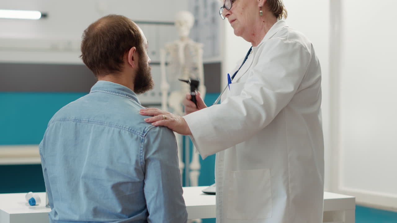 Female otolaryngologist consulting patient in medical cabinet