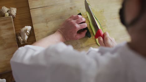 caucasian female chef cutting zucchini