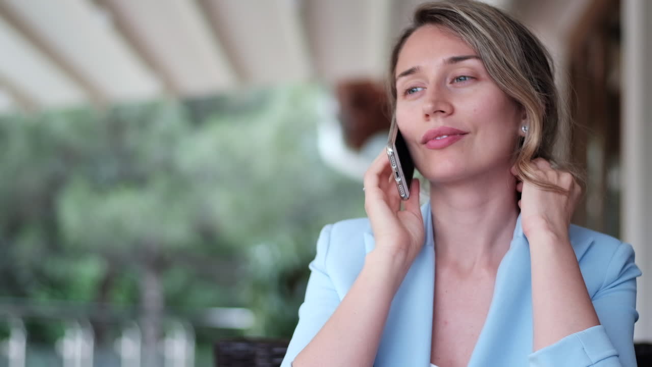 Brunette woman in a blue blazer talking on the phone at a restaurant