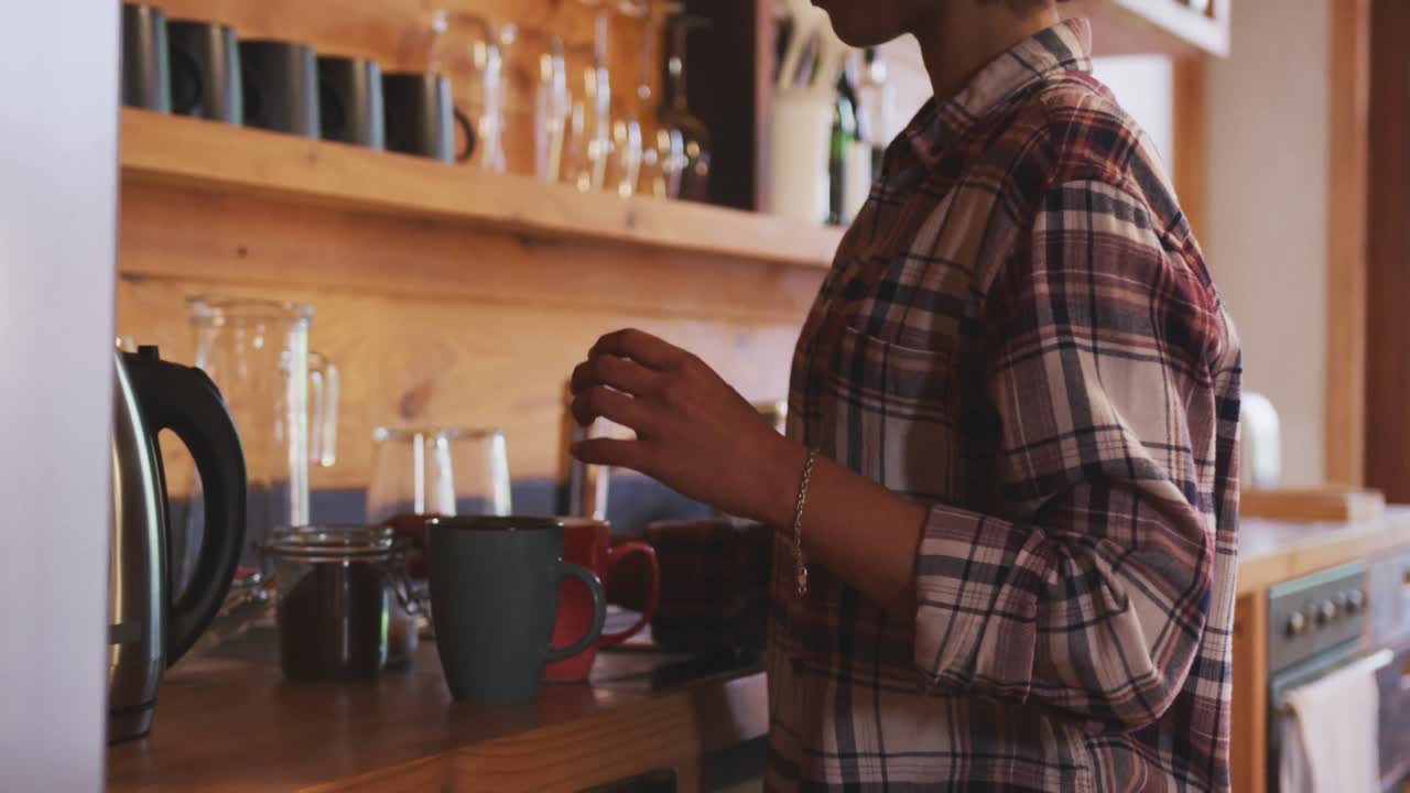 mujer de raza mixta preparando café en casa
