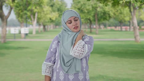 muslim woman suffering from neck pain in park