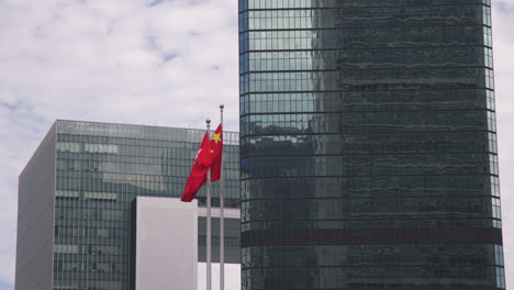 hong kong and china flags in business districts with skyscraper buildings