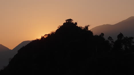 sunset over mountain peak with lookout hut