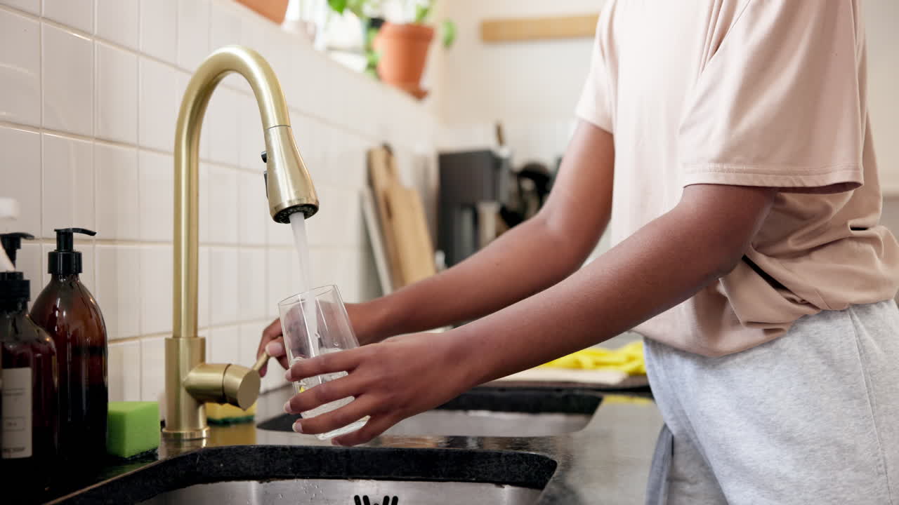 Filling a glass of water in the kitchen