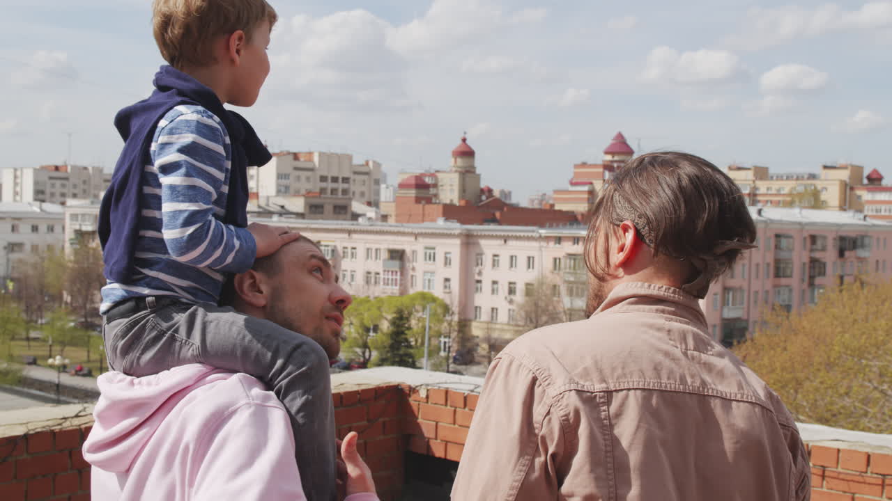 Fathers and Little Son Standing on Roof and Looking at City