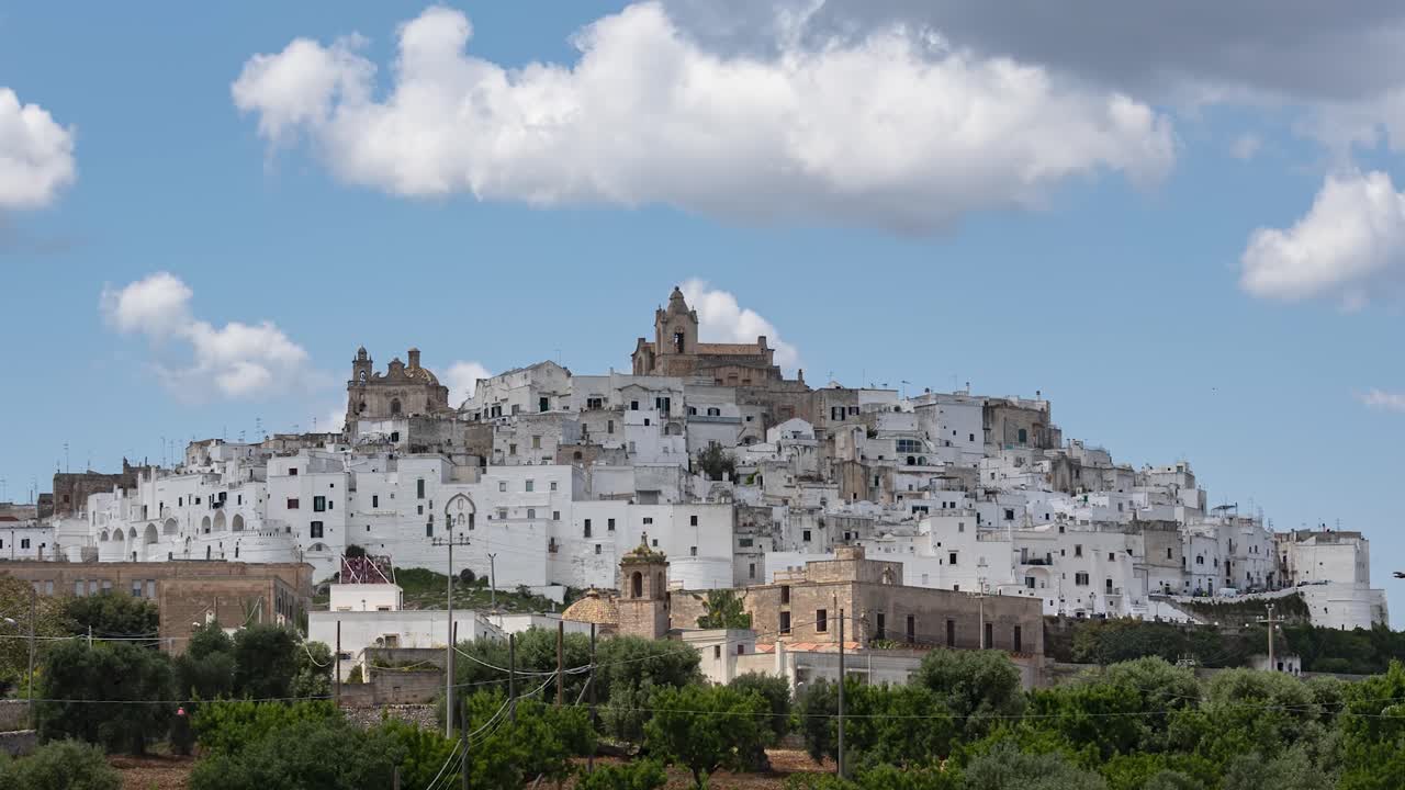 Time lapse of white old city Ostuni in Puglia, Italy, on sunny day with cumulus clouds