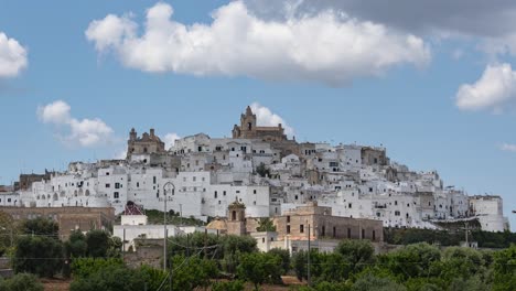 time lapse of white old city ostuni in puglia, italy, on sunny day with cumulus clouds