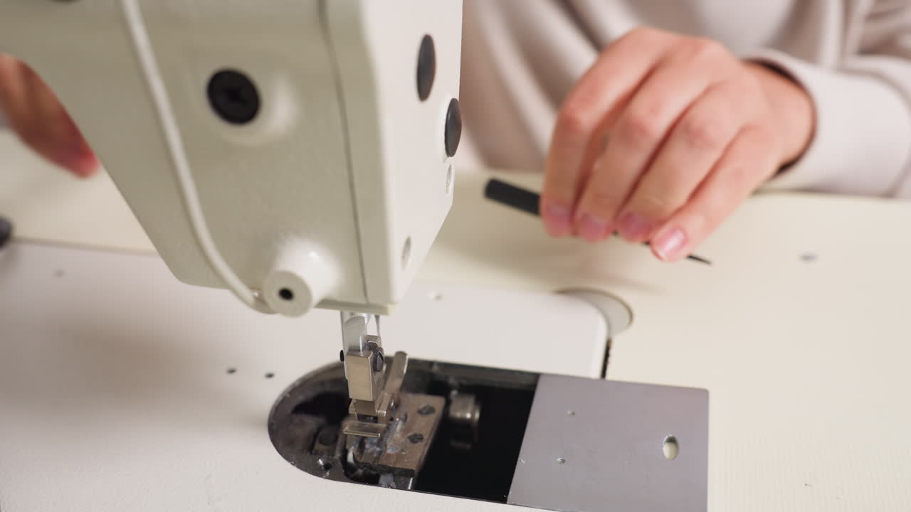 Overhead view female hand firmly tightening screw nut inside sewing machine, focusing on mechanical precision, showcasing approach and dedicated skill in bright workspace, ensuring smooth operation