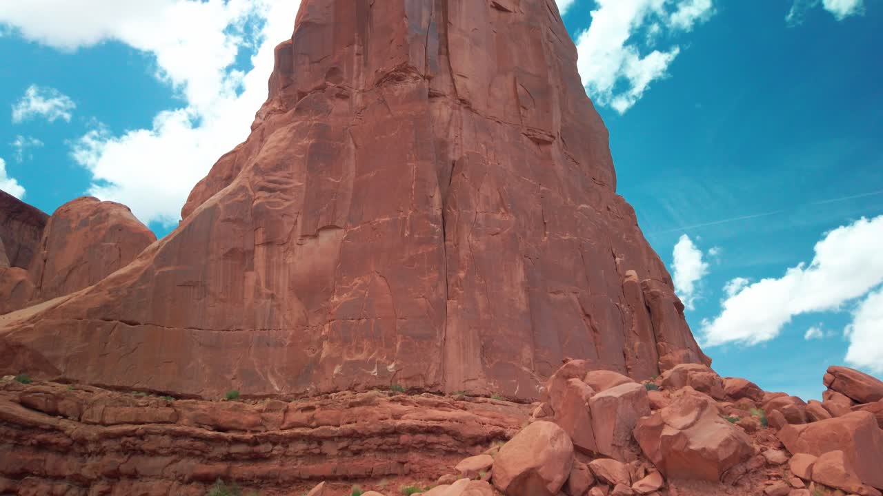 Inquadratura panoramica verso l'alto di un'enorme roccia arenaria nel deserto