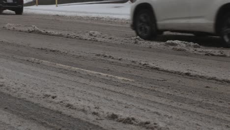 a snowy, muddy road on a cold winter day - tilt down shot