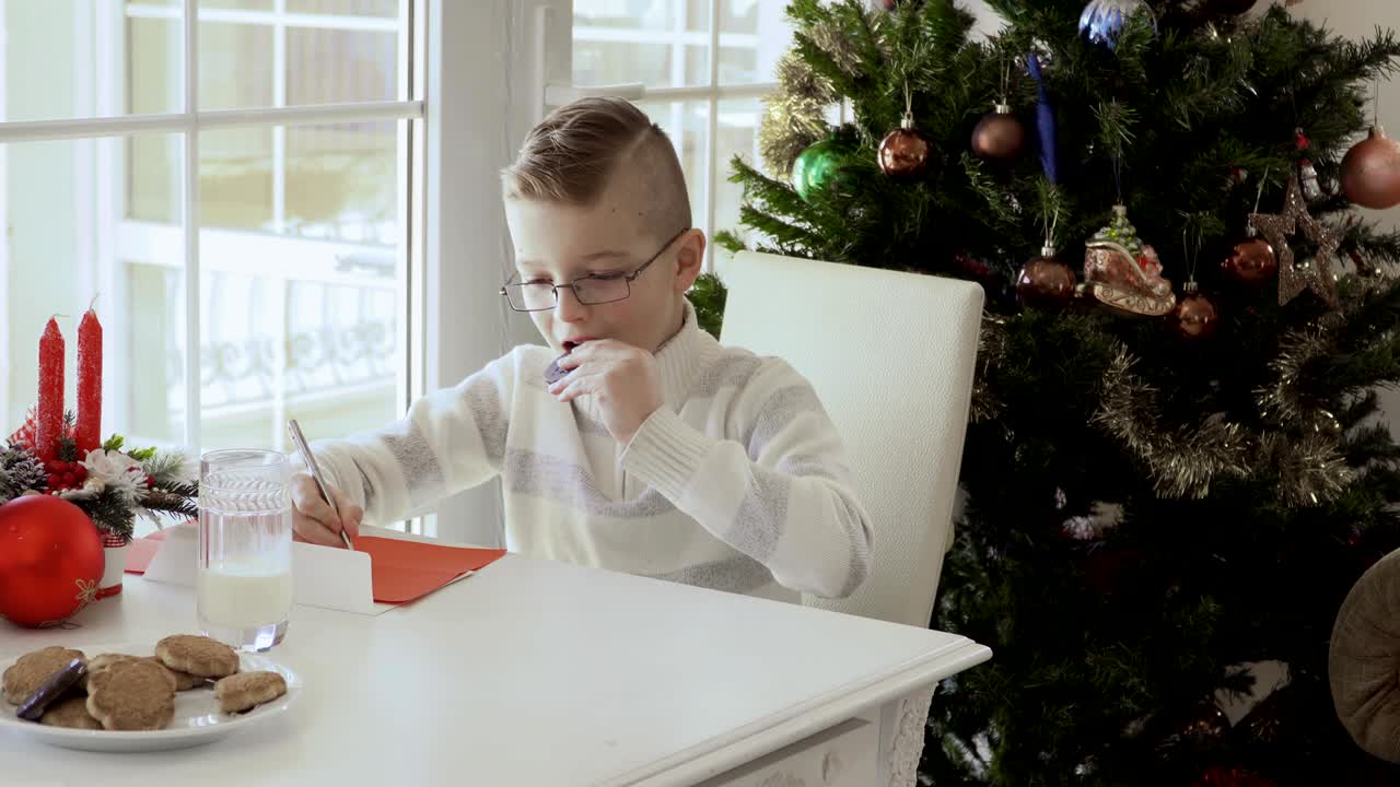 사랑스러운 작은 소년은 산타클로스에 소원 목록을 쓴다