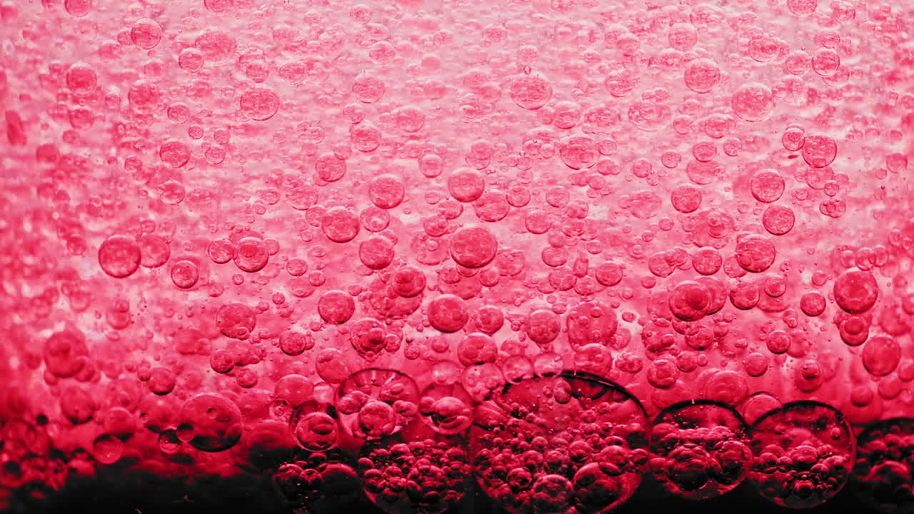 물 속의 어두운 바닥에 있는 많은 붉은 거품의 매크로 샷