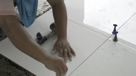throwing the leveling clips on the floor and installing them one by one around a square tile to keep them in place.