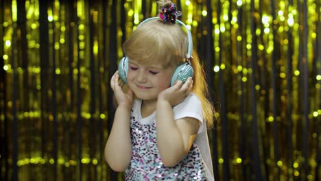 child dances, listens music on headphones. little kid girl dancing, having hun, relaxing, enjoying