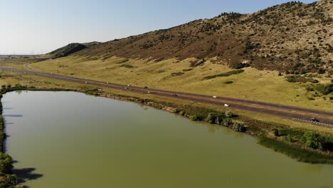 A-drone-shot-over-a-man-made-lake-adjacent-to-a-freeway