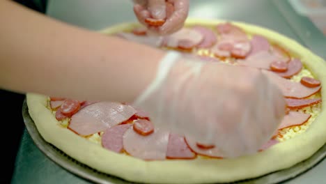생 피자 에 베이컨 과 흡연 소시지 를 넣어 요리 한다