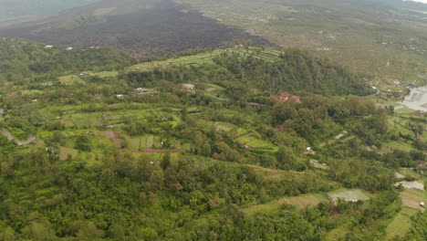 Reveal-of-the-Lake-Batur-surrounded-by-tropical-rainforest-in-Bali,-Indonesia.-Aerial-dolly-shot-of-large-lake-surrounded-by-wild-natural-landscape