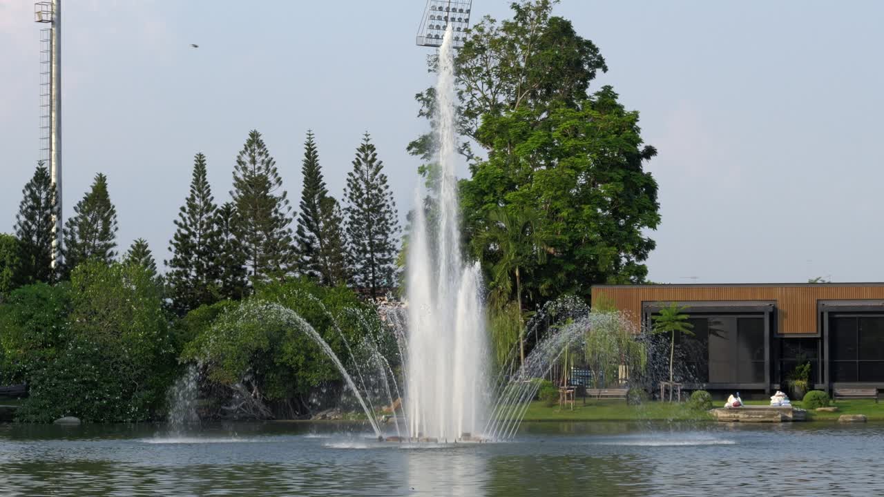 Una vista pintoresca de una fuente rociando agua en un tranquilo parque con lago