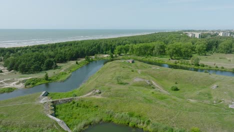 Blick-Aus-Der-Luft-Auf-Verlassene-Historische-Betonbefestigungsgebäude-Am-Meer,-Südliche-Festungen-In-Der-Nähe-Des-Ostseestrandes-In-Liepaja,-Sonniger-Sommertag,-Weite-Drohnenaufnahme,-Die-Sich-Vorwärts-Bewegt