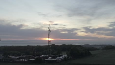 sunrise lowering in telecom towers aerial view on agricultural farmland at dawn