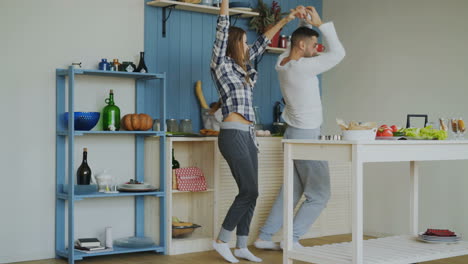couple cooking and dancing in the kitchen