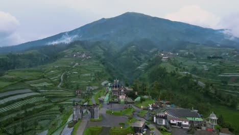 Orbit-drone-shot-of-"Negeri-Kahyangan"-outdoor-park-with-view-of-Mount