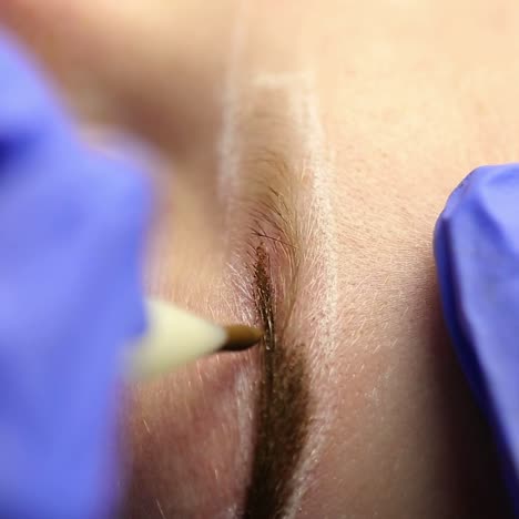 vrouw in het proces van wenkbrauw tatoeage