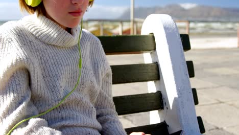 girl listening music on headphones at beach 4k