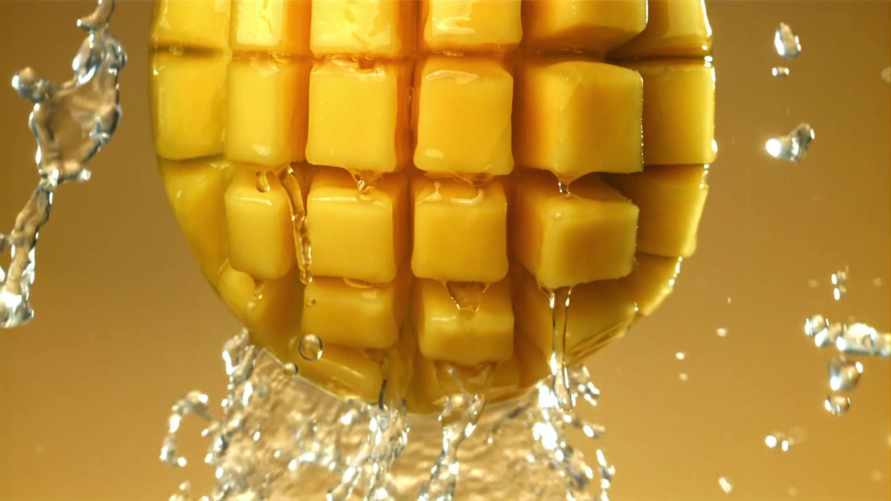 Acqua che schizza su mango fresco a cubetti al rallentatore.