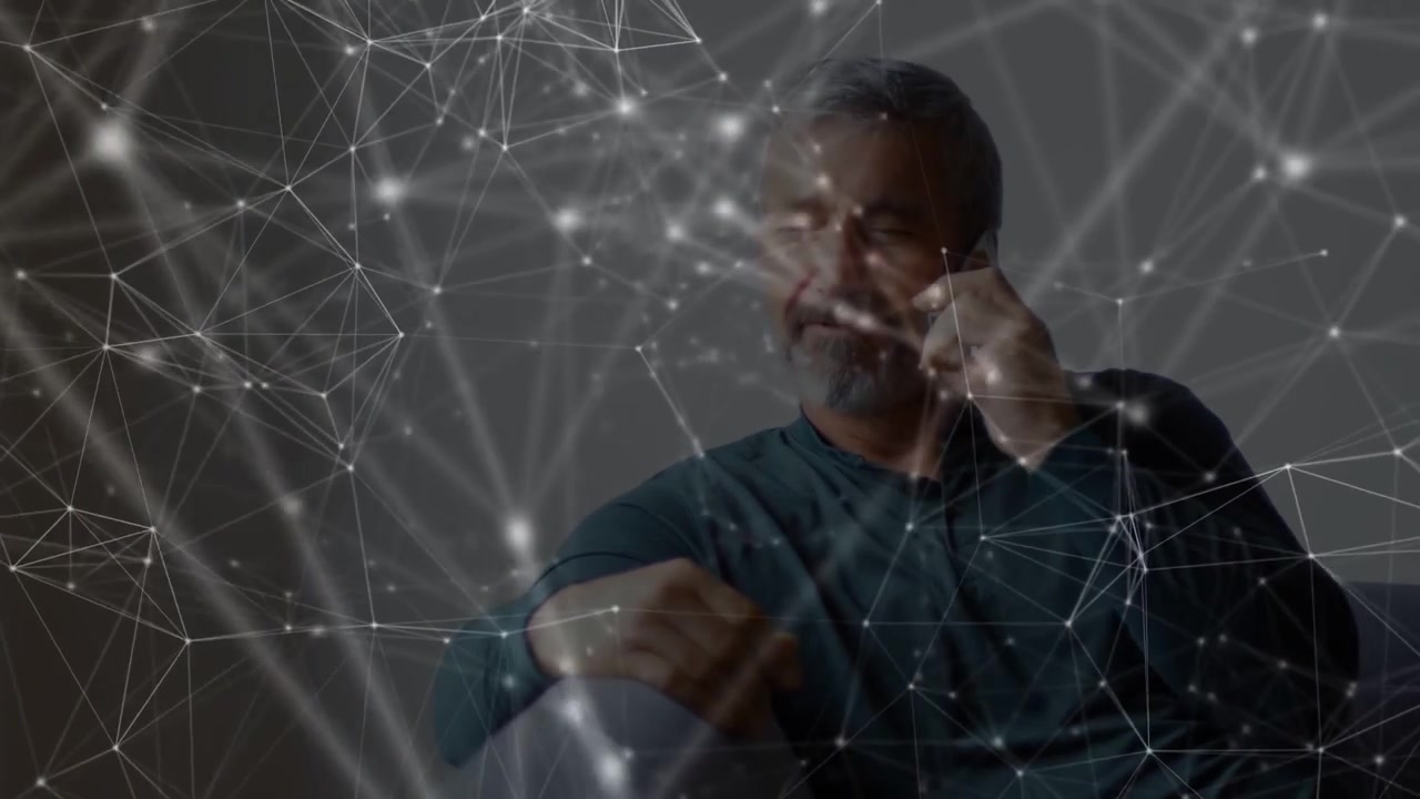 Man answering incoming phone call in lounge, animated network mapping links while engaging in call