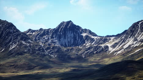 laderas de color marrón rojo y picos de montañas cubiertos de nieve