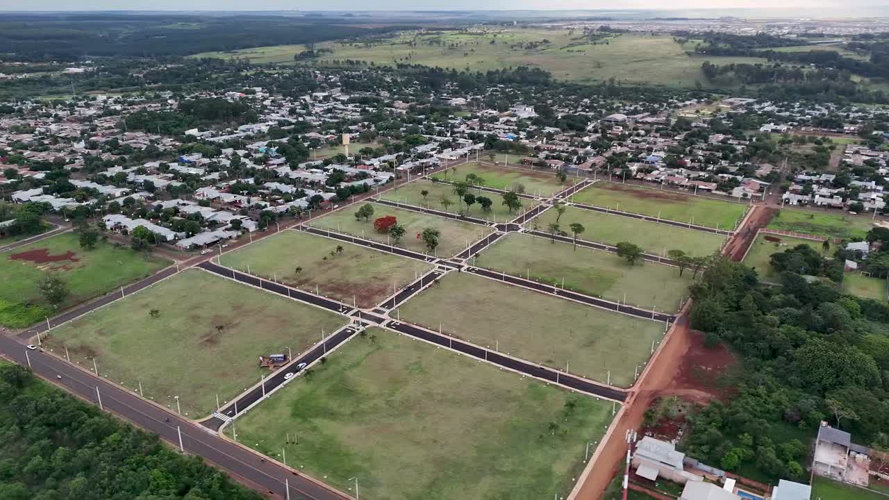 Drone orbits above cleared, vegetated housing lots ready for development in suburban area during cloudy afternoon