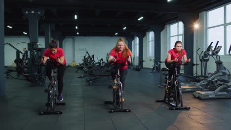 group of girls performs aerobic training workout cardio routine on bike simulators, cycle training